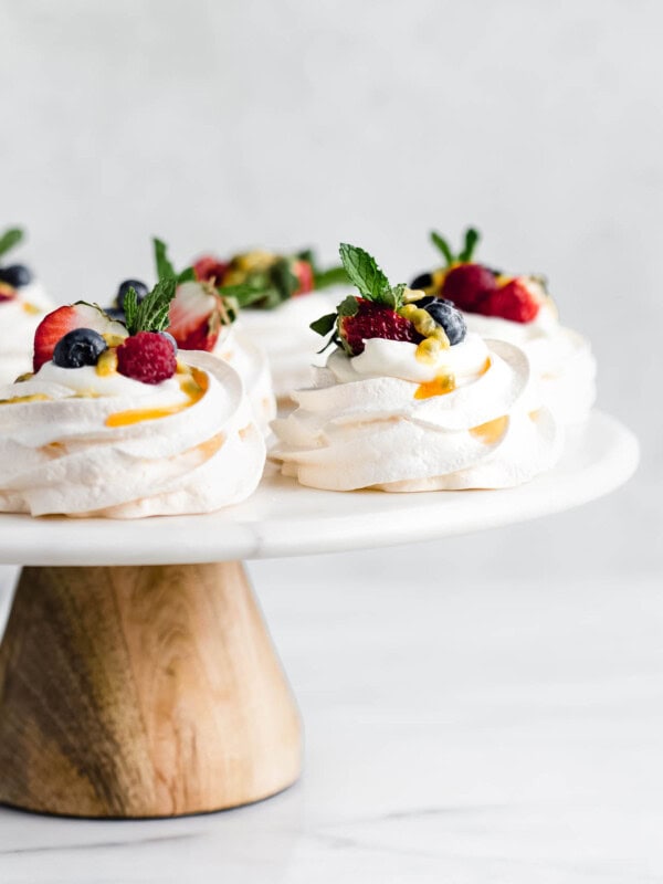 mini pavlovas on a marble and wood cake stand