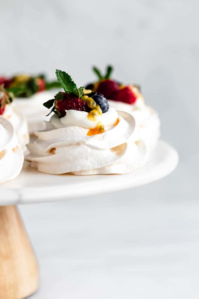 Mini pavlova on a cake stand topped with berries