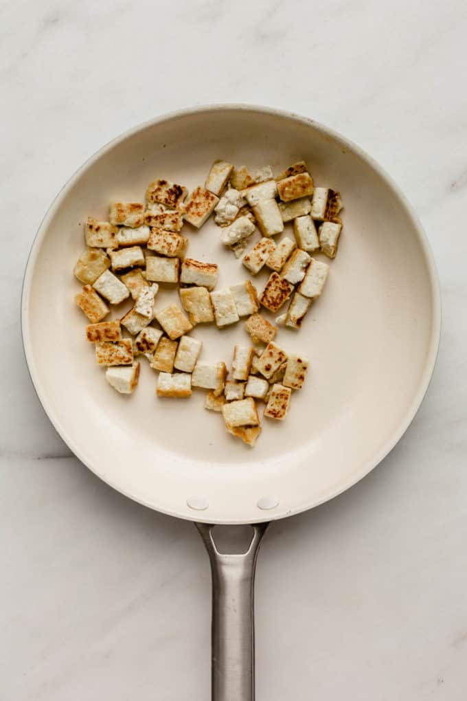 A white pan with cubes of tofu in it