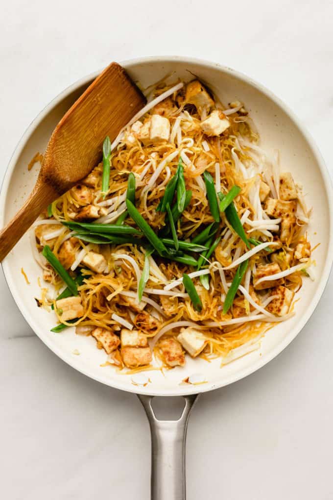 Spaghetti squash, tofu and green onions in a white pan