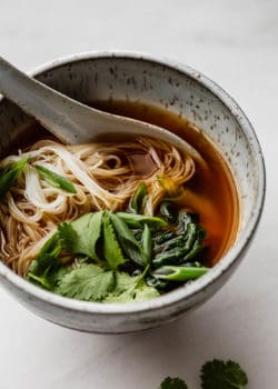 Vegan pho in a speckled blue ceramic bowl