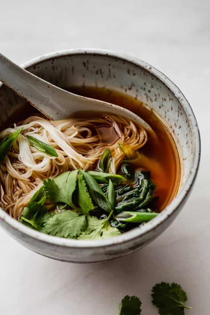 Vegan pho in a speckled blue ceramic bowl