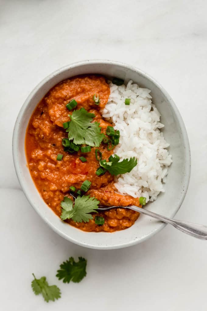 A bowl with rice and lentil curry in it