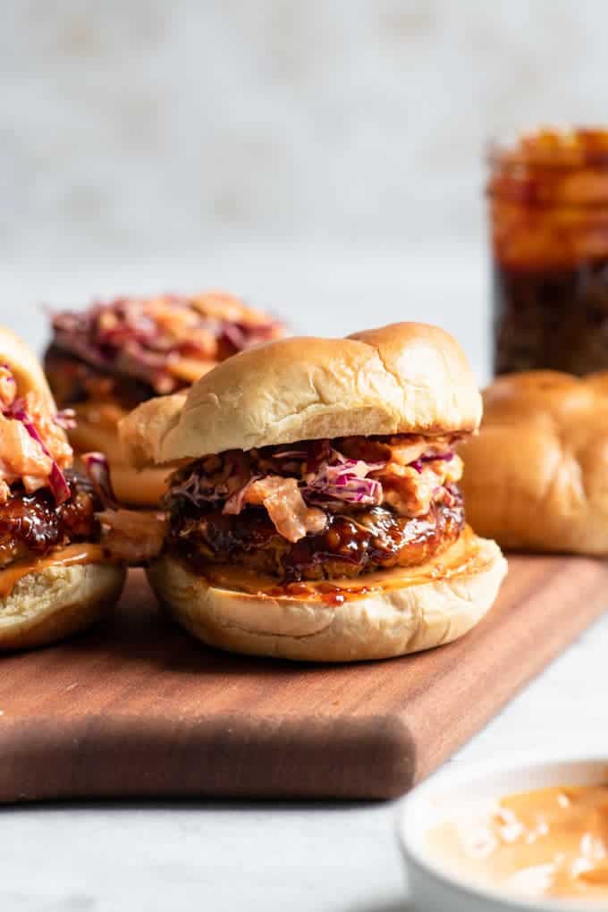 A wood tray with tempeh burgers on it