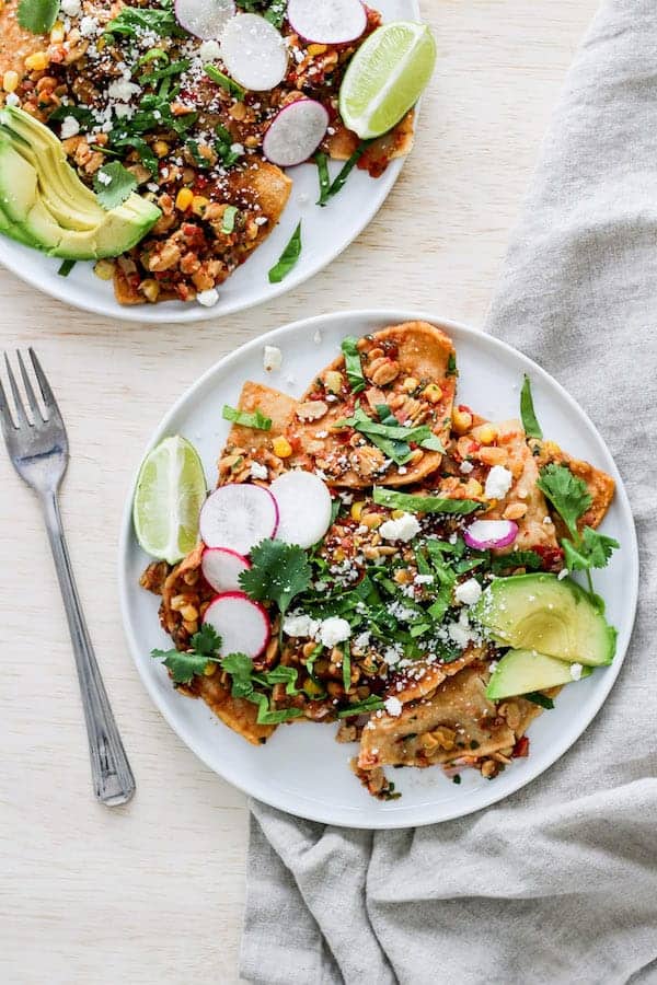 A plate with tempeh and nachos on it with a fork on the side