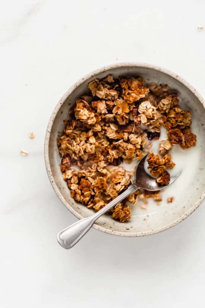 A bowl with banana granola and almond milk in it