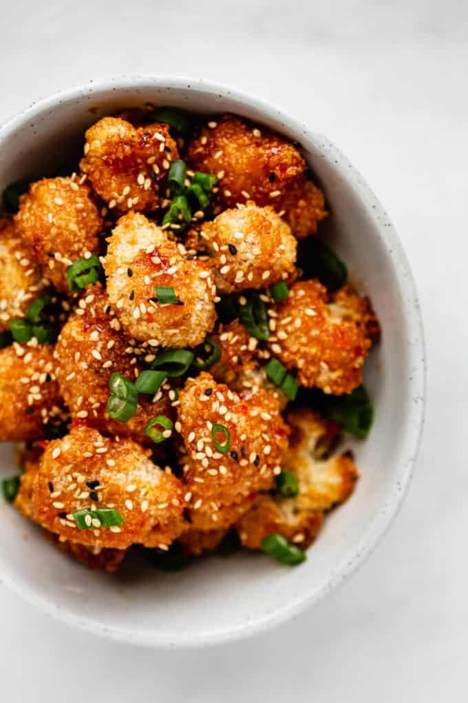A bowl of panko cauliflower topped with green onions