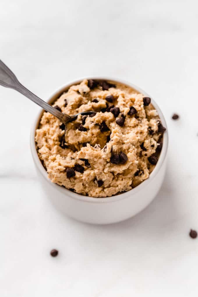 chickpea cookie dough in a small white bowl with a spoon in it