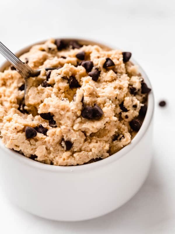 a close up of chocolate chip chickpea cookie dough in a small white bowl