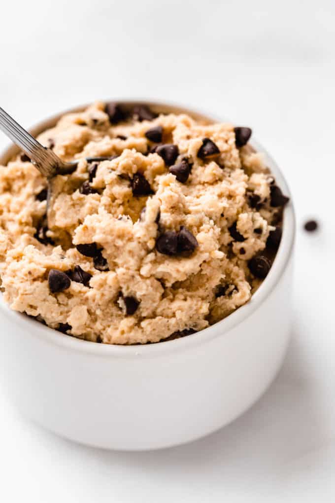 a close up of chocolate chip chickpea cookie dough in a small white bowl