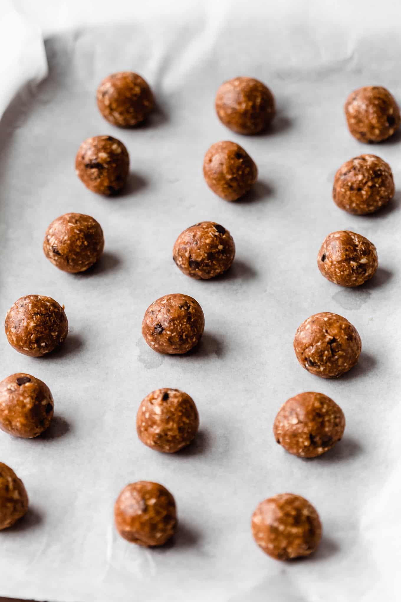 Peanut butter protein balls on a baking sheet with parchment paper