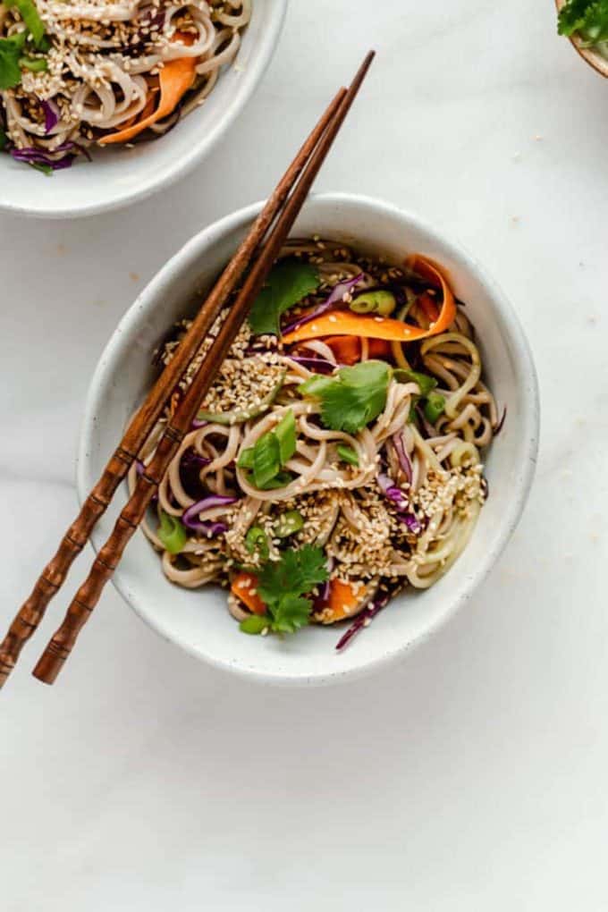 A bowl of soba noodles topped with sesame seeds