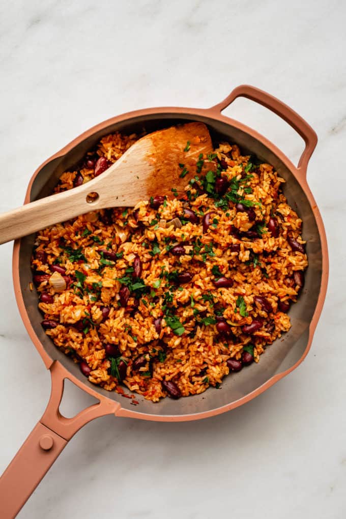 a pan of spanish rice and beans topped with parsley