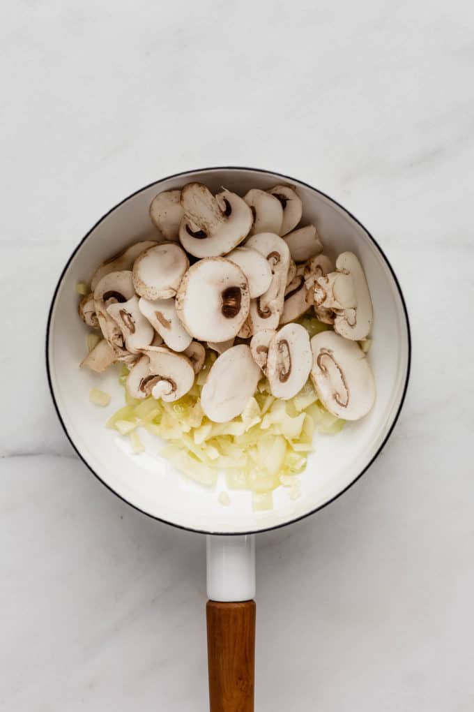 onions and mushrooms in a white pot