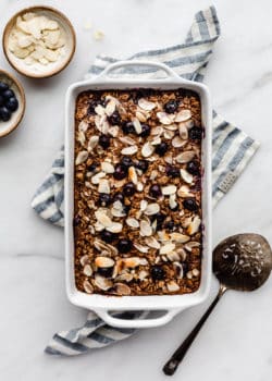 A baking dish with blueberry baked oatmeal in it on a blue napkin