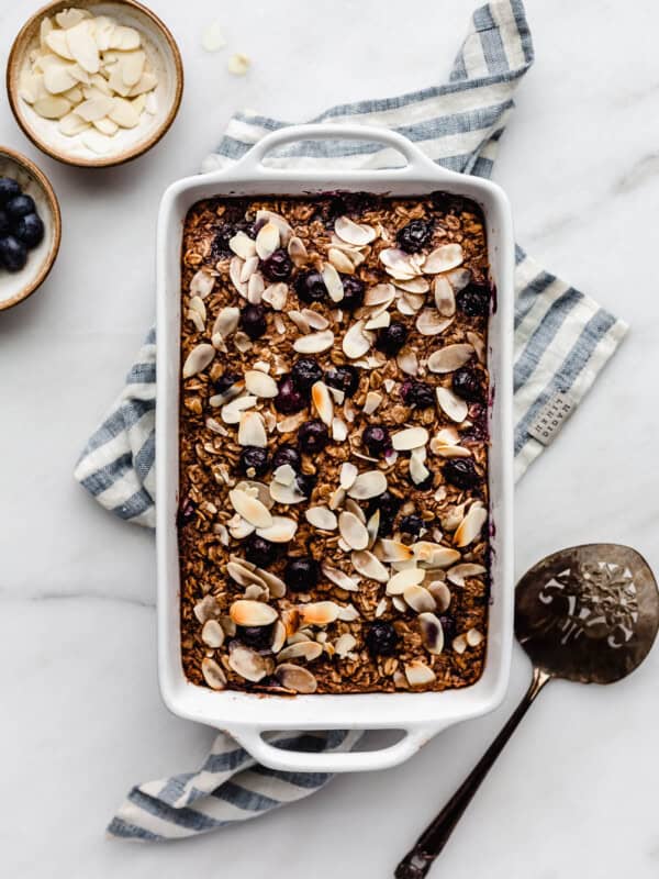 A baking dish with blueberry baked oatmeal in it on a blue napkin
