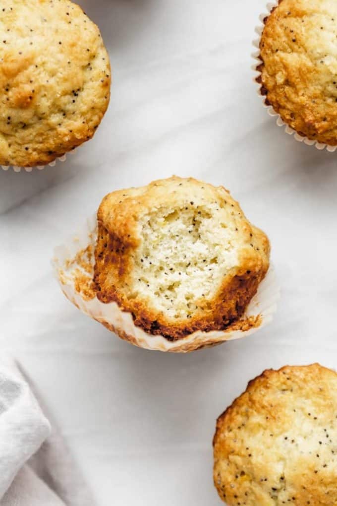 lemon poppyseed muffin with a bite taken out of it it