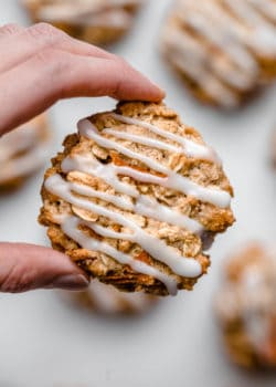 A hand holding a carrot cake cookie