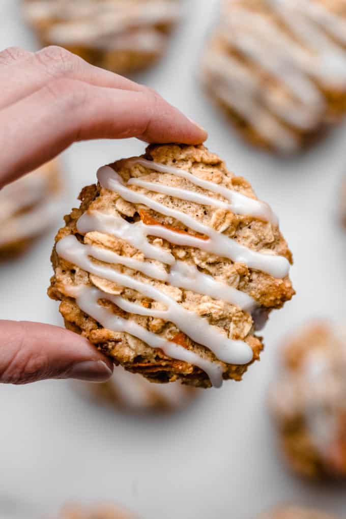 A hand holding a carrot cake cookie