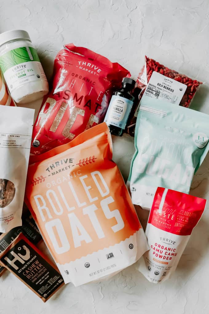 A flat lay of health food products including rolled oats, chocolate, coconut sugar and rice
