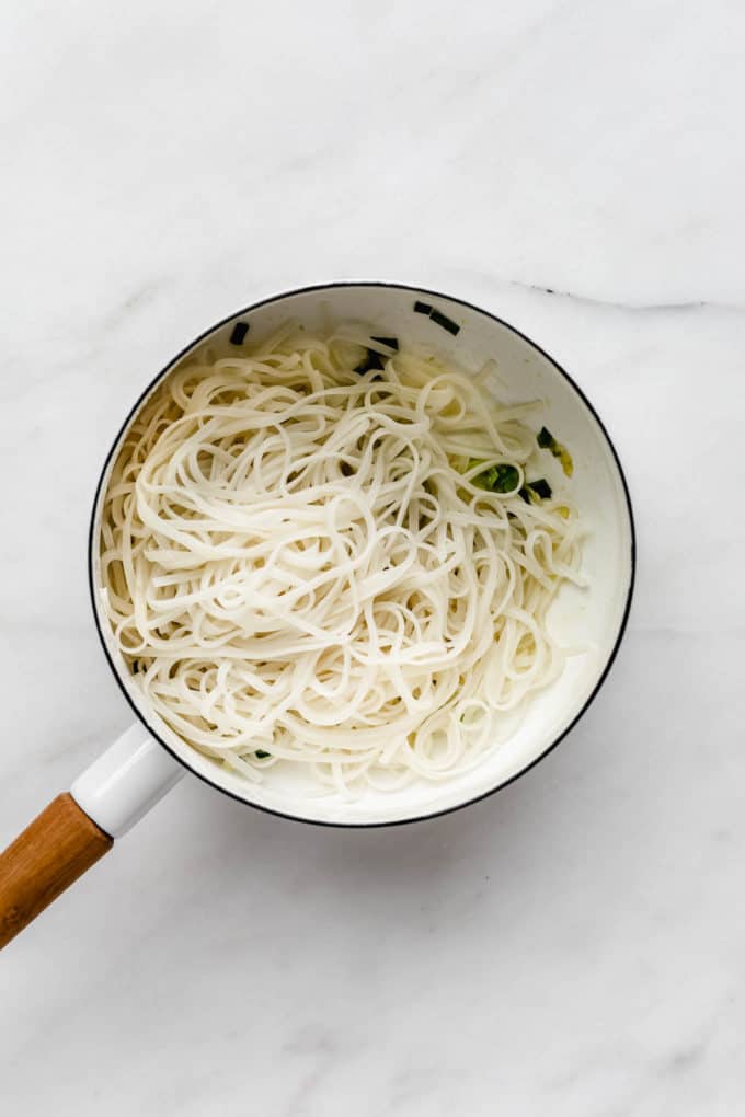 A white pot with rice noodles in it