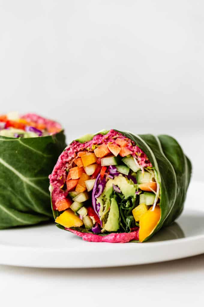 A rainbow collard green wrap on a white plate