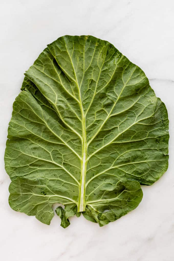 A collard green leaf on a marble board