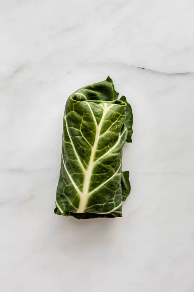 A collard green wrap on a marble board