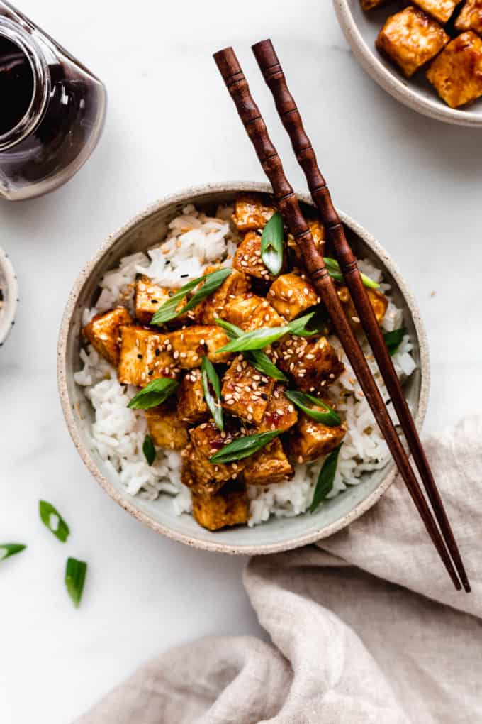 A bowl of teriyaki tofu with a napkin on the side
