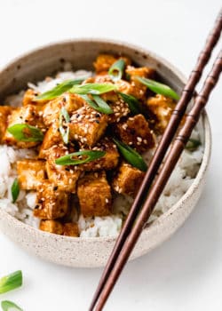 teriyaki tofu in a ceramic bowl with wooden chopsticks