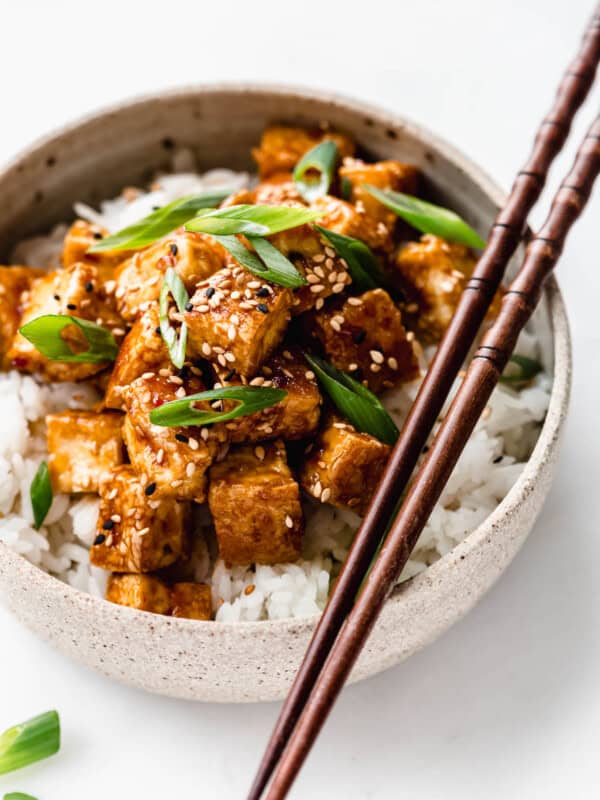 teriyaki tofu in a ceramic bowl with wooden chopsticks