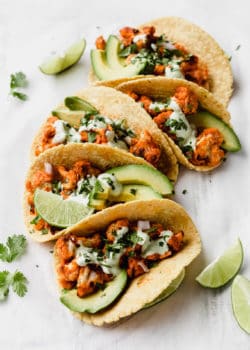 buffalo cauliflower tacos with cilantro sauce and cilantro on top
