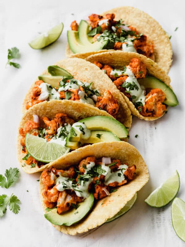 buffalo cauliflower tacos with cilantro sauce and cilantro on top