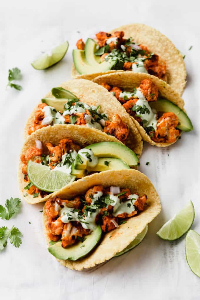 buffalo cauliflower tacos with cilantro sauce and cilantro on top