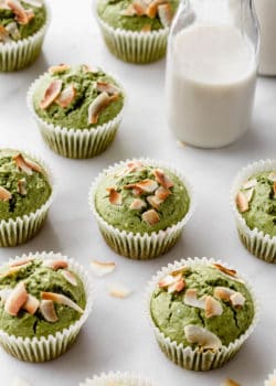 matcha coconut muffins on a marble counter with a jar of milk