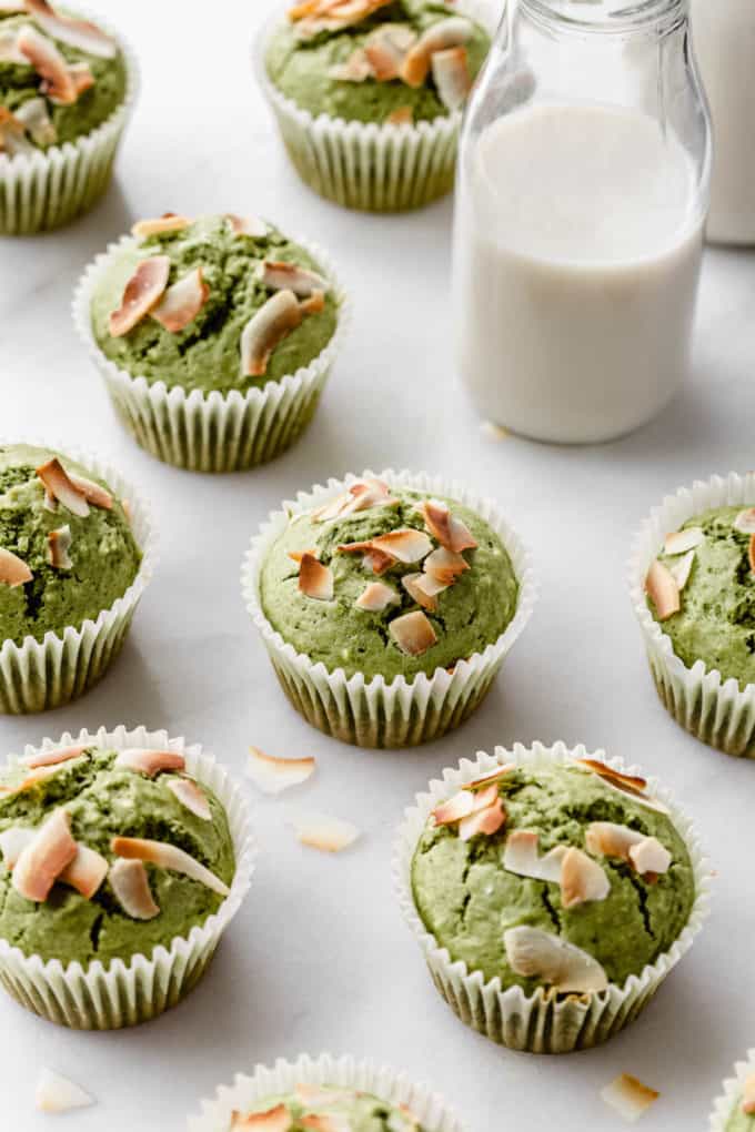 matcha coconut muffins on a marble counter with a jar of milk