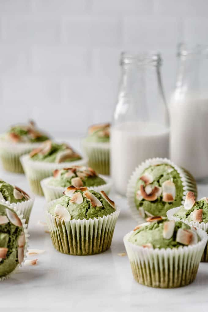 matcha coconut muffins with 2 jars of milk in the back