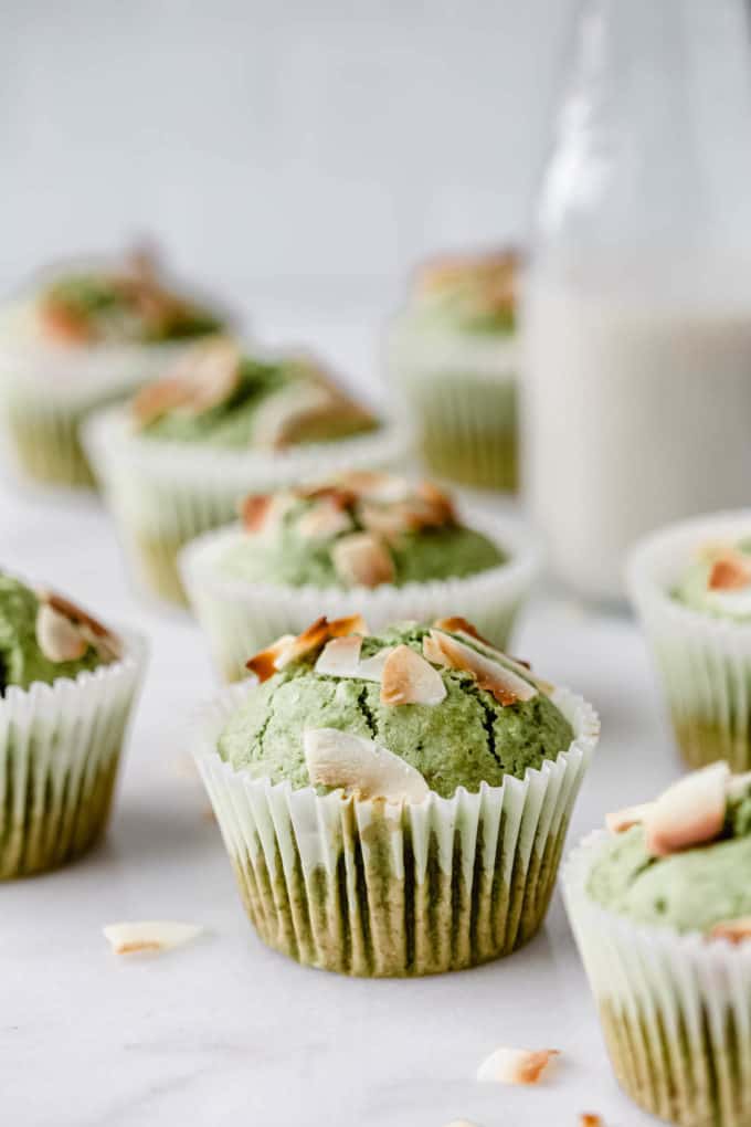 a matcha coconut muffin topped with coconut flakes