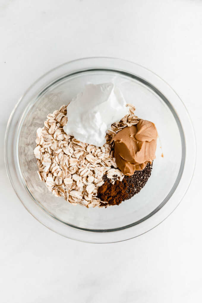 oats, yogurt, peanut butter and chia seeds in a clear mixing bowl