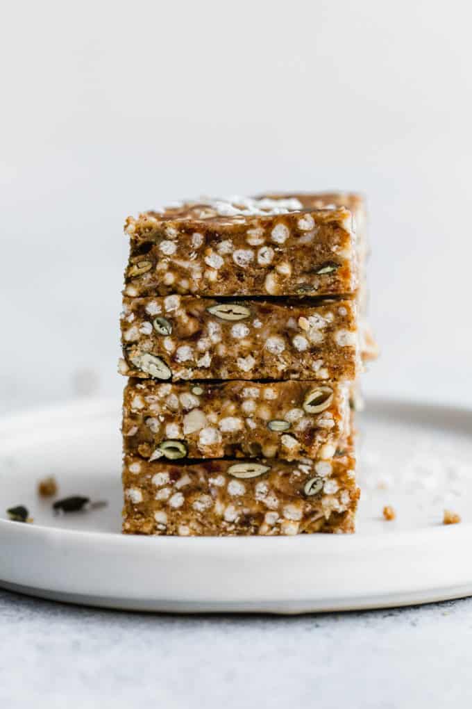 four puffed quinoa bars stacked on a white plate