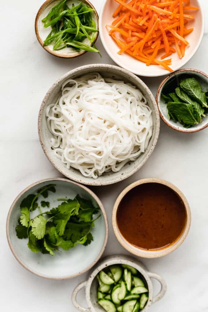 bowls filled with ingredients to make spring rolls