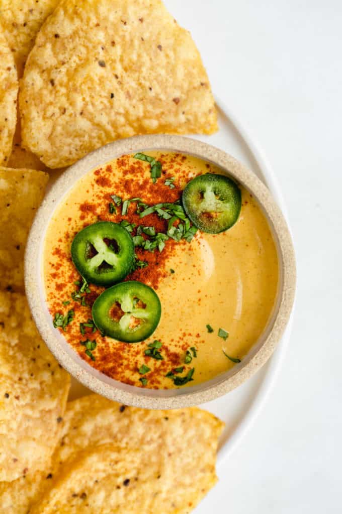 A bowl of dairy-free queso cheese topped with sliced jalapenos