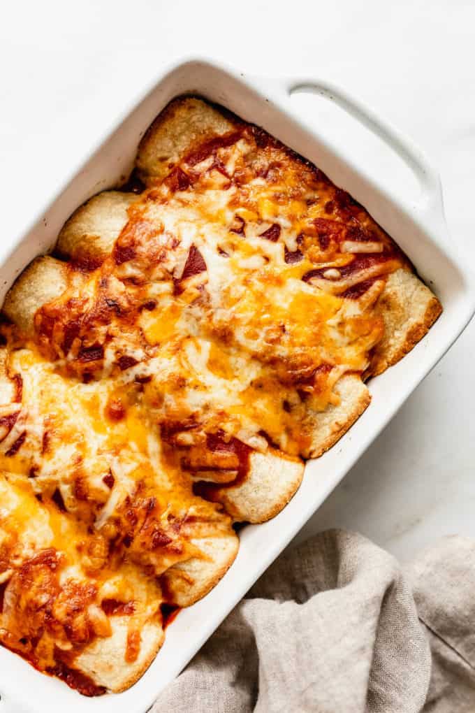 baked veggie enchiladas in a white baking dish