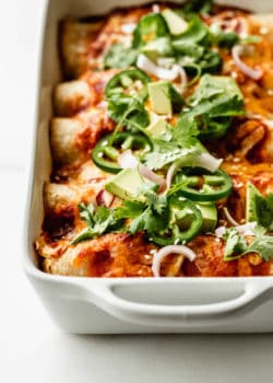 veggie enchiladas topped with jalapeno, avocado and cilantro