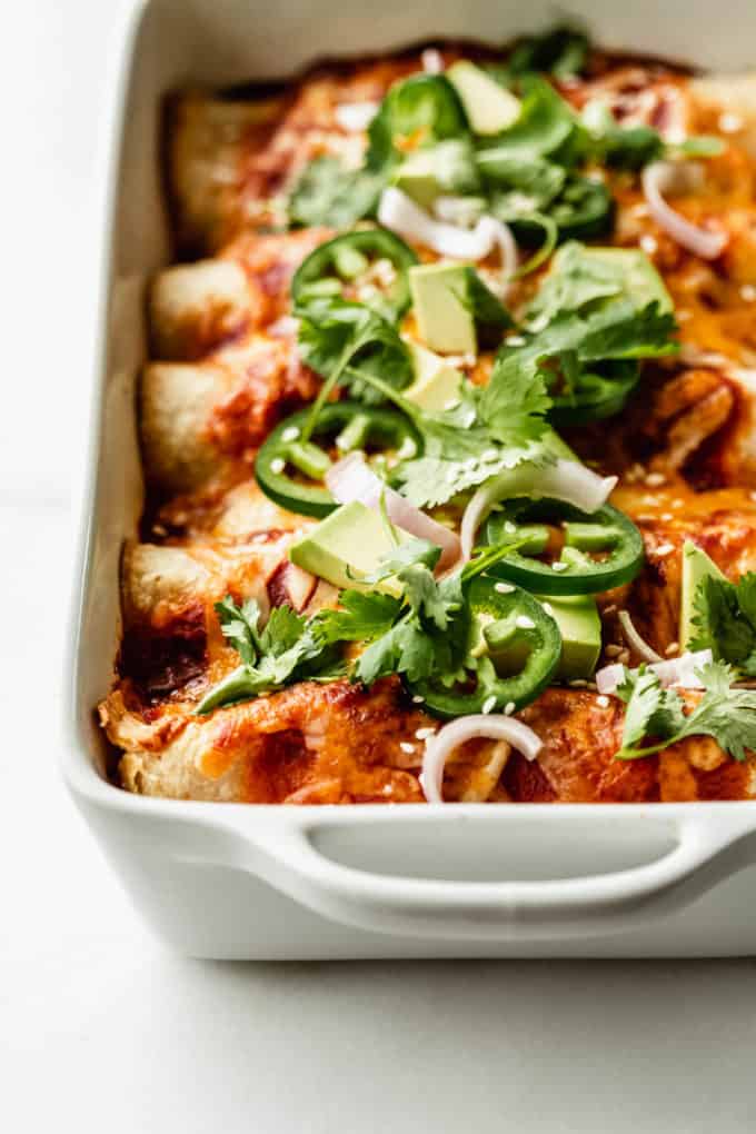 veggie enchiladas topped with jalapeno, avocado and cilantro