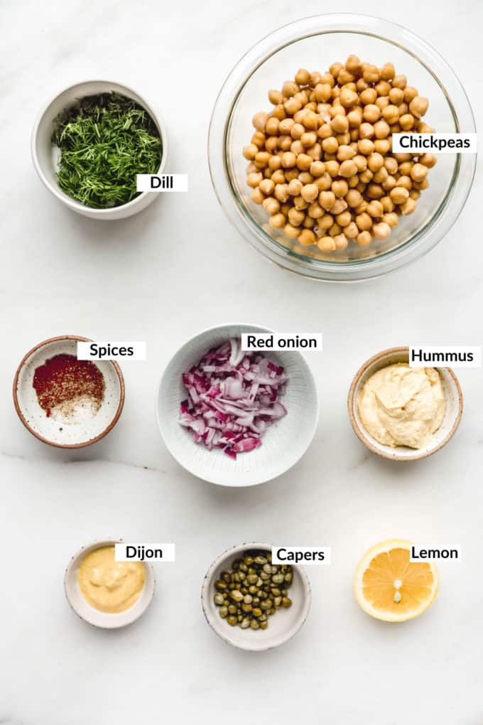 Ingredients for smashed chickpea salad sandwich laid out on a marble board