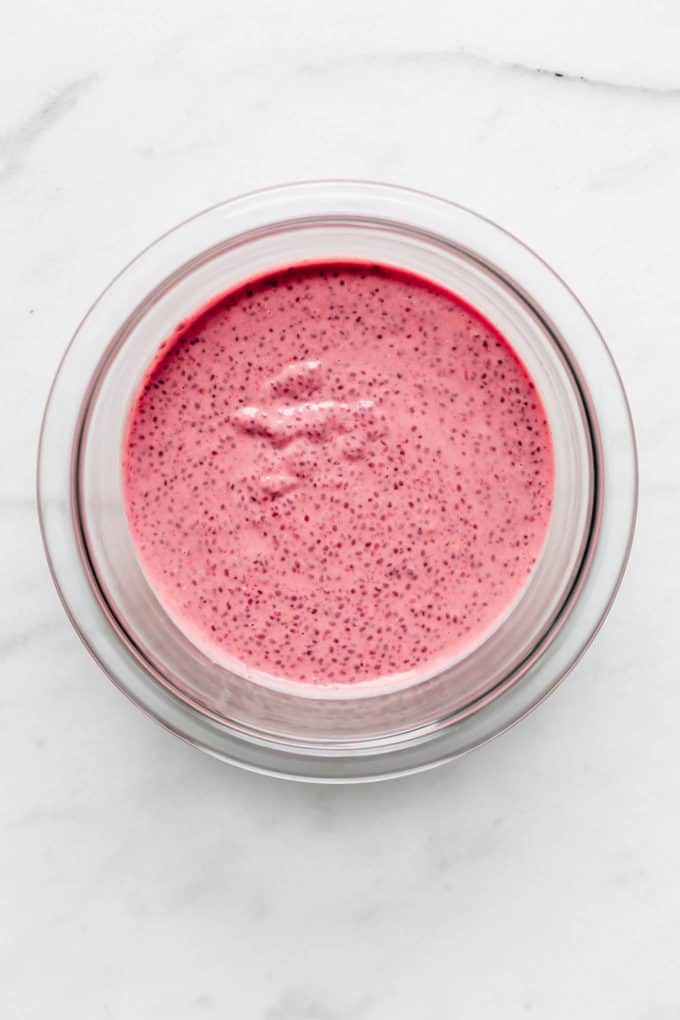 raspberry chia pudding in a clear mixing bowl