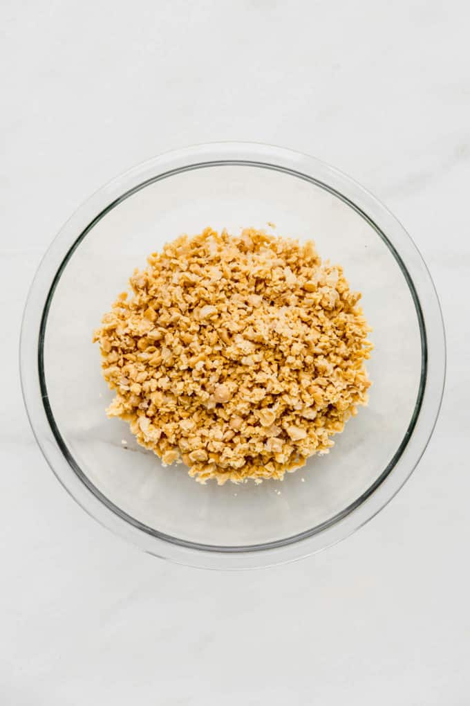 smashed chickpeas in a clear mixing bowl