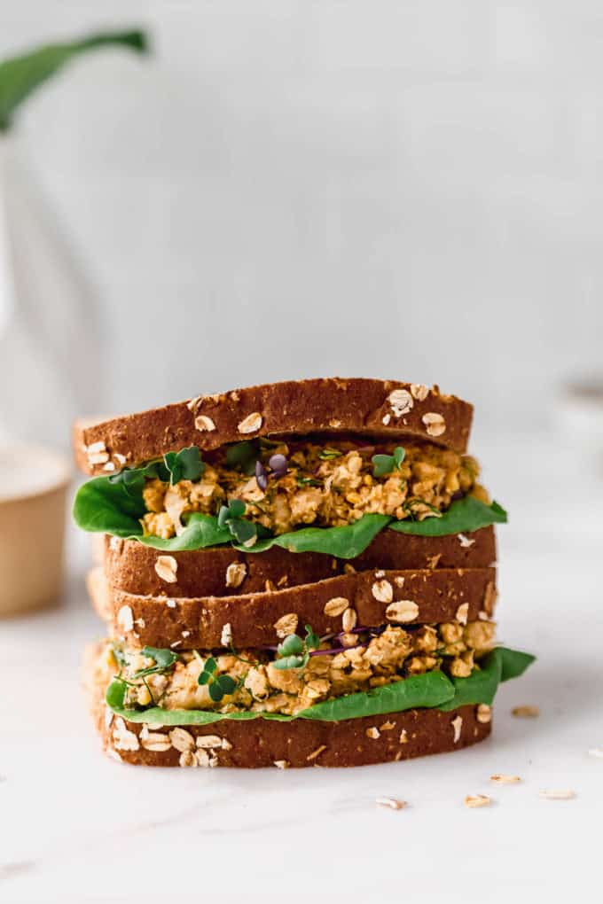 two smashed chickpea salad sandwiches stacked on top of each other