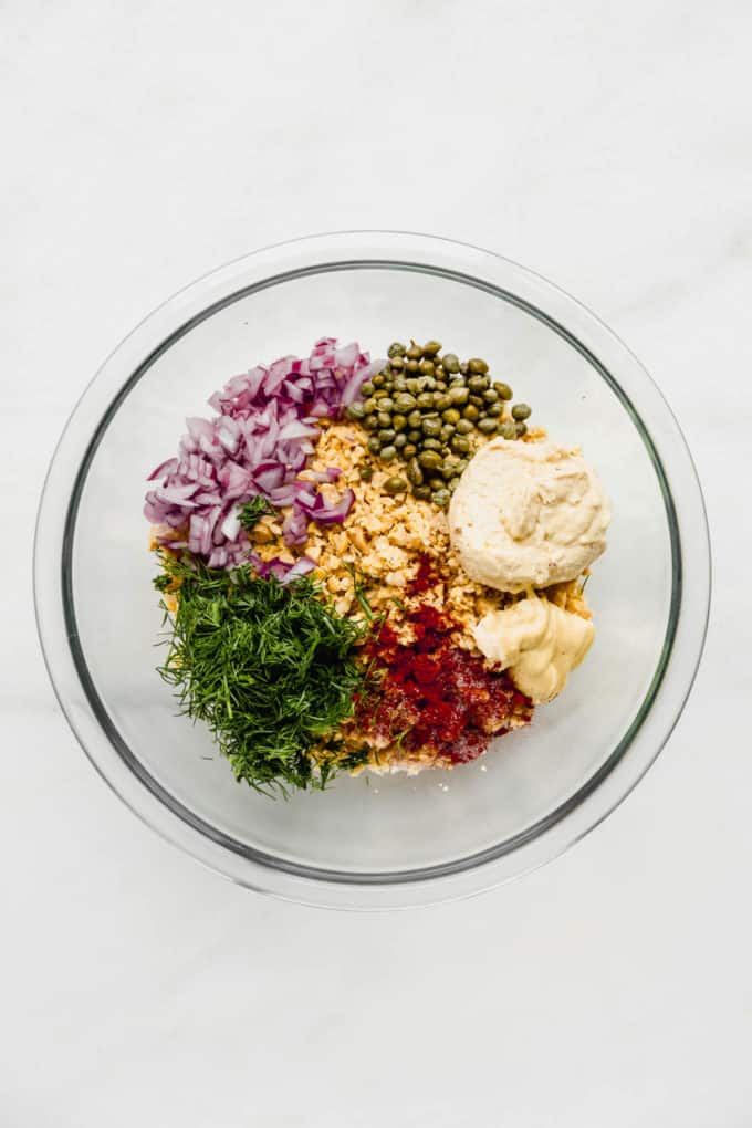 smashed chickpea salad ingredients in a clear mixing bowl